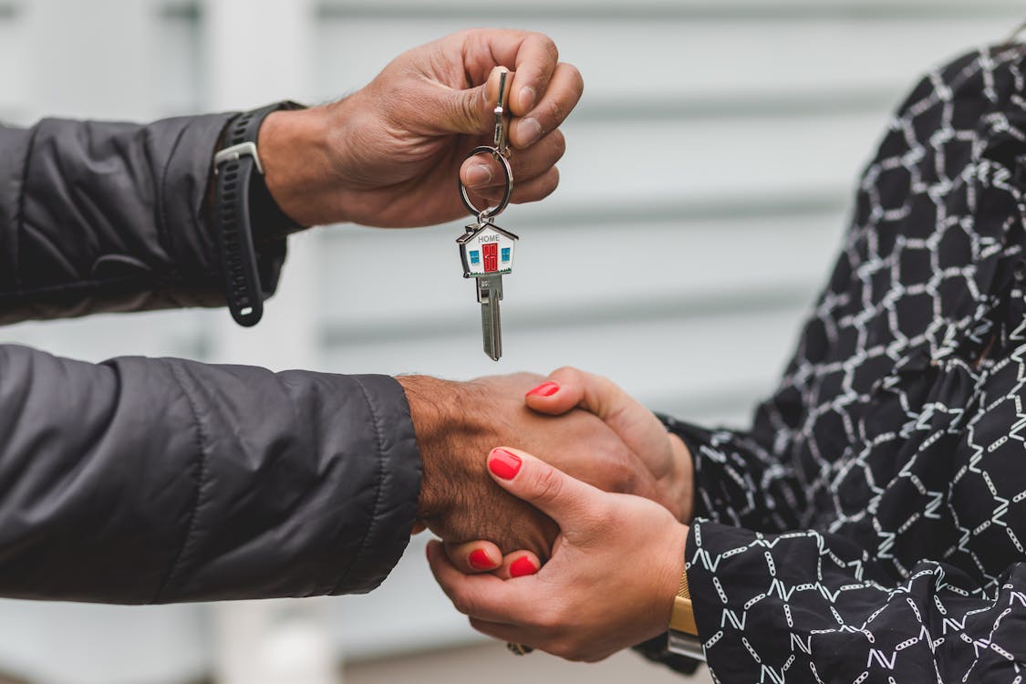 The Tech Behind the Savings: Comparing the Apps and Tools of Top Discount Brokers 3 A top-down view of a clean, modern desk with a smartphone placed next to a set of house keys, symbolizing the connection between financial tech and homeownership.