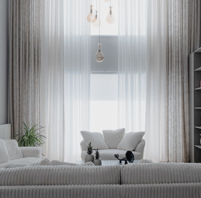 Beautifully furnished, bright and airy living room in a modern coastal vacation home, with neutral-toned furniture and lar...