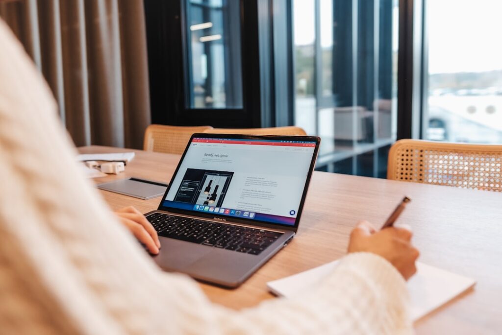 SEO innovator for real estate meticulously reviews architectural blueprints on a laptop, symbolizing the strategic plannin...