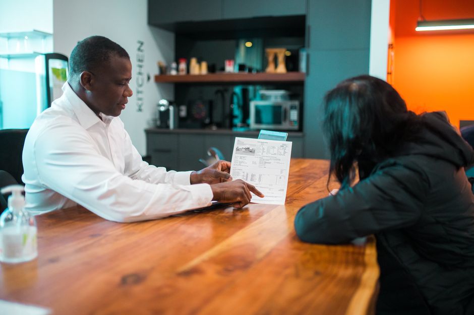 Full Service, Lower Fees: A Home Seller's Guide to Discount Realtors on the New Orleans Northshore 3 A happy couple sits at their bright, modern kitchen island, reviewing papers together, symbolizing the smart financial decisions involved in selling a home.