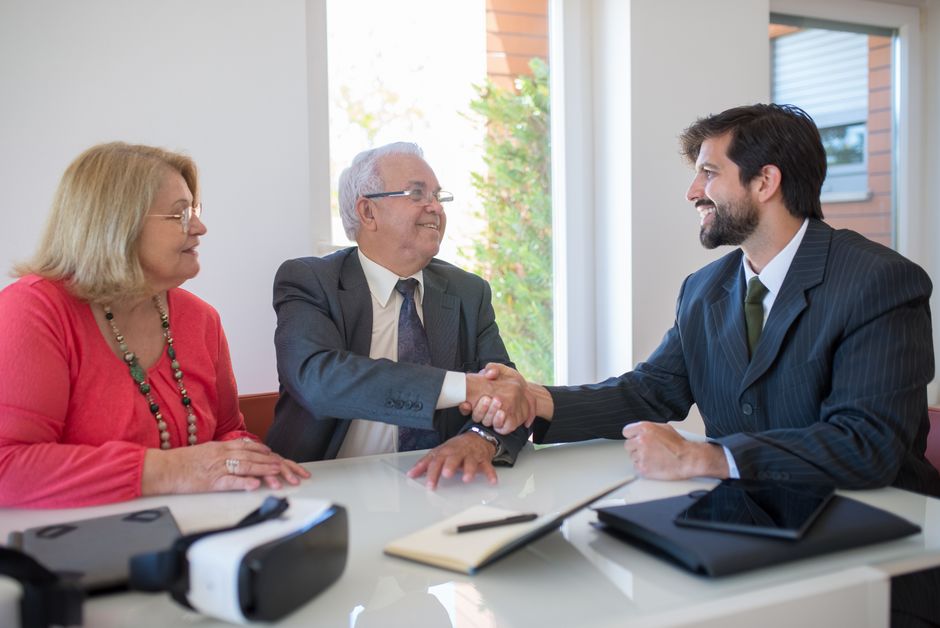 Full Service, Lower Fees: A Home Seller's Guide to Discount Realtors on the New Orleans Northshore 4 A professional real estate agent warmly shakes hands with a homeowner in front of a house, representing a successful, full-service partnership and a closed sale.